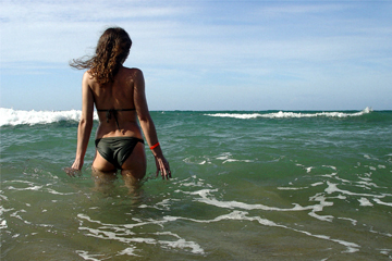 Female in green bikini standing in green sea