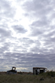 An old fishing boat and tumbled-down shack under a brooding sky