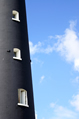 three lighthouse windows against a blue summer sky