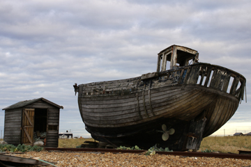 an old fishing boat and a wooden hut