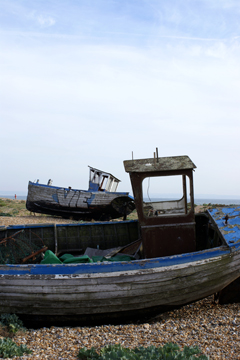 Two old blue fishing boats on the shore