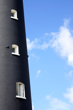 three lighthouse windows against a blue summer sky