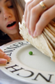 girl lifts pile of tortillas to find a pea