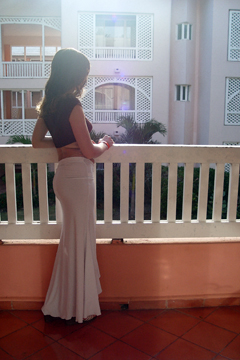 woman standing on a hotel balcony in the morning sunlight