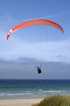 man parascending onto a beach