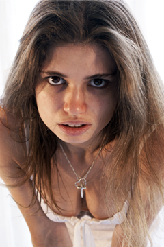 Female in white lace staring into camera